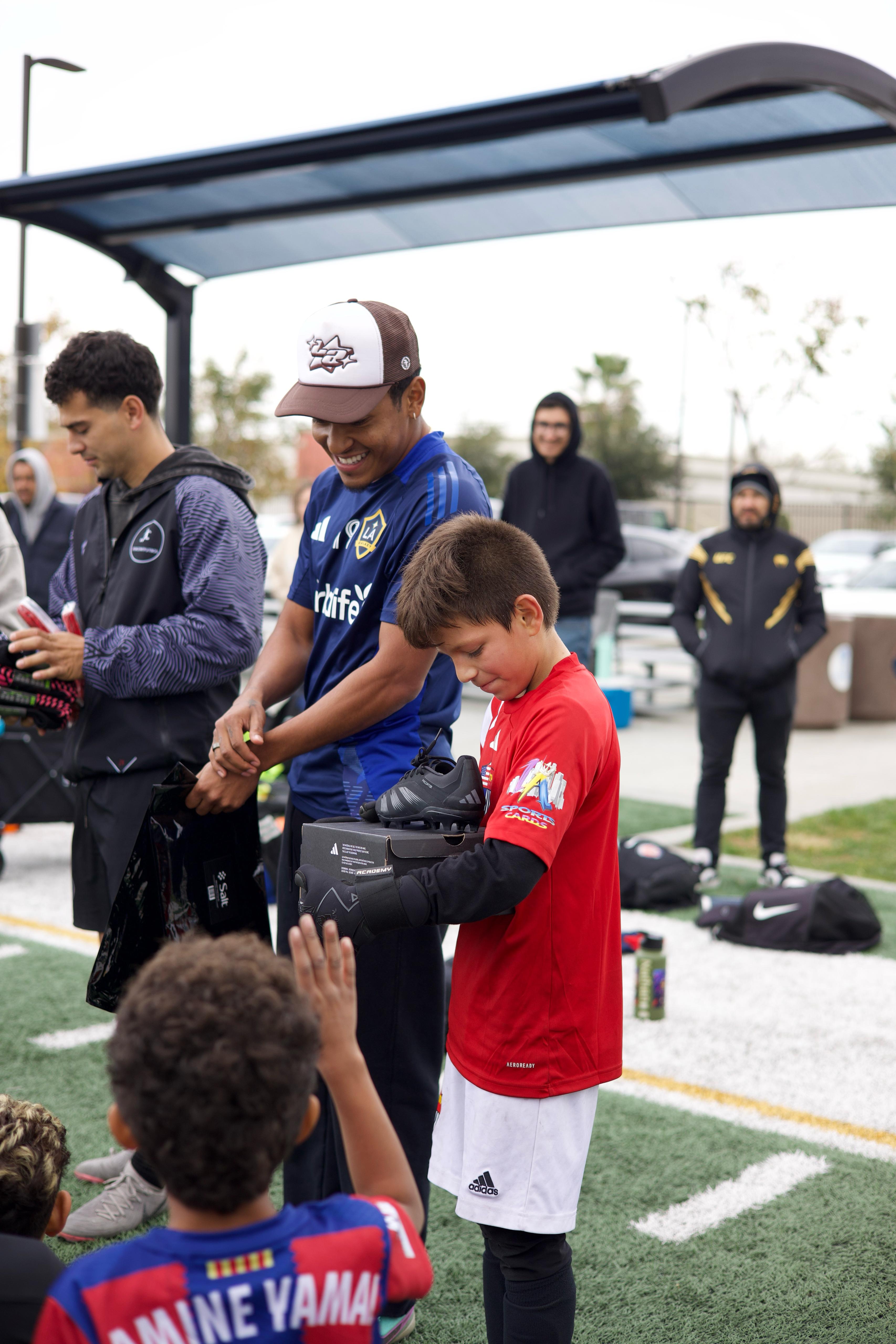 Coach helping young player with football equipment