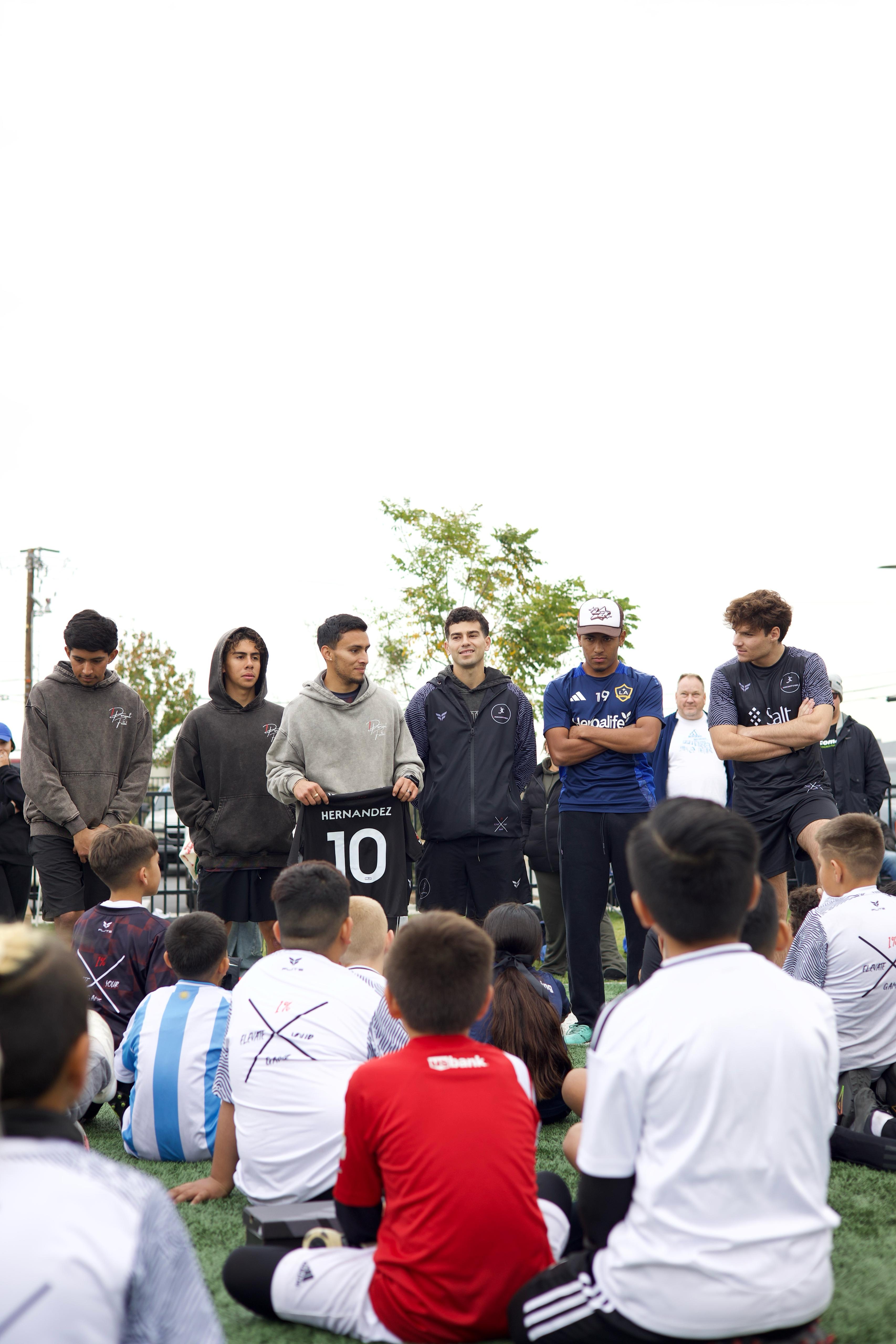 1PERCENTFUTBOL coach presenting jersey to young players